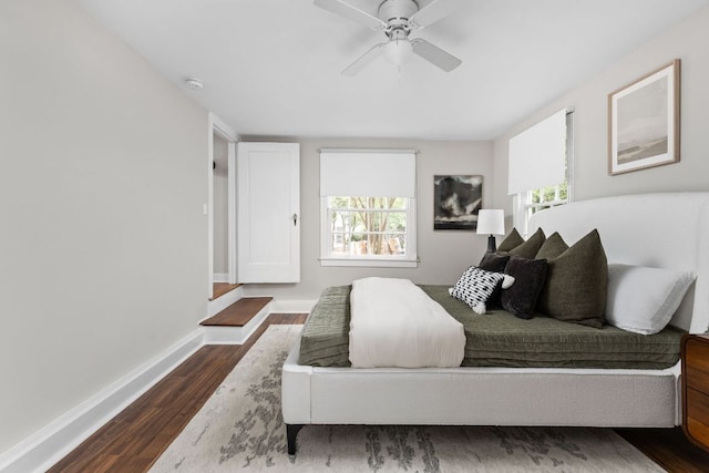 bedroom with baseboards, a ceiling fan, and dark wood-style flooring