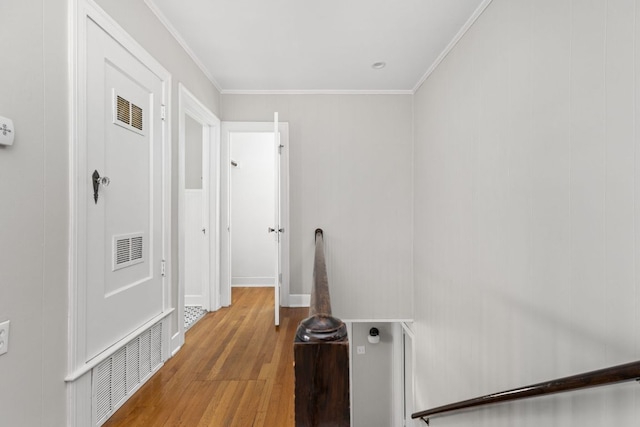 corridor featuring visible vents, wood finished floors, and ornamental molding