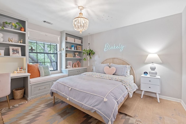 129 The Hills Dr, The Hills, TX 78738 - bedroom with a chandelier, light wood-style flooring, and baseboards
