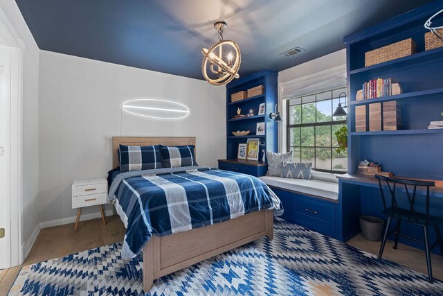 129 The Hills Dr, The Hills, TX 78738 - bedroom with a chandelier, wood finished floors, and baseboards
