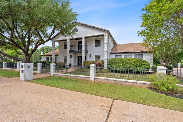 129 The Hills Dr, The Hills, TX 78738 - neoclassical home with a balcony, a tiled roof, and a gate