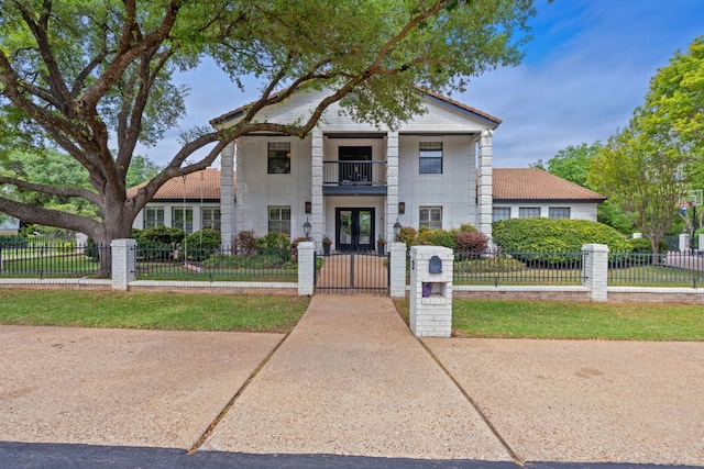 129 The Hills Dr, The Hills, TX 78738 - townhome / multi-family property featuring french doors, a gate, a balcony, and a fenced front yard