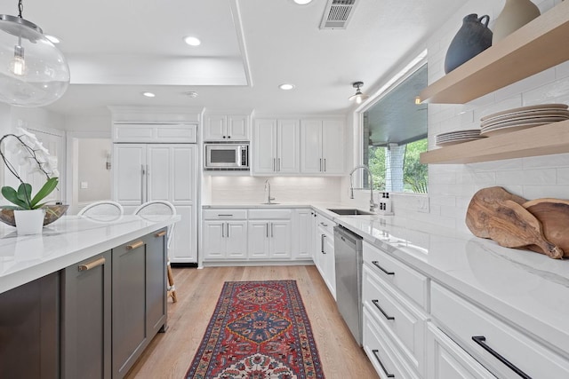 129 The Hills Dr, The Hills, TX 78738 - kitchen featuring open shelves, a sink, stainless steel appliances, light wood-type flooring, and white cabinets