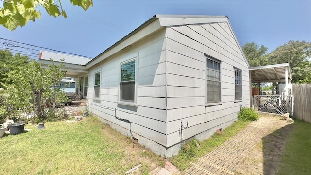 view of home's exterior featuring fence and a lawn