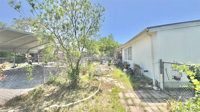 view of yard with a detached carport and fence