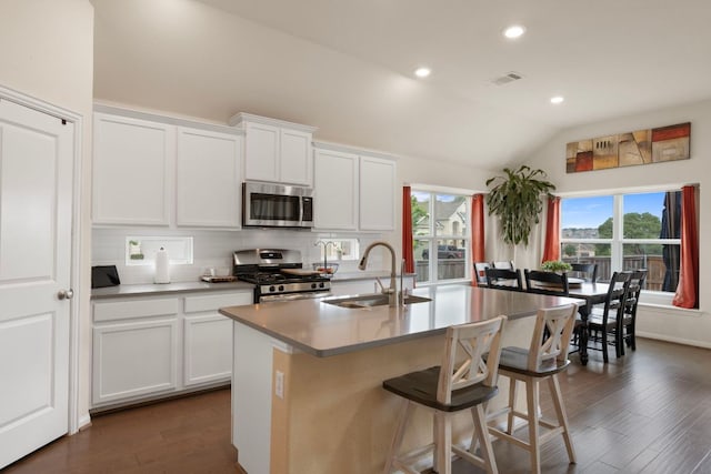 607 Panzano Dr, Georgetown, TX 78628 - kitchen with stainless steel appliances, lofted ceiling, dark wood-style floors, an island with sink, and backsplash