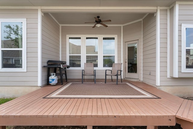 wooden terrace with area for grilling and ceiling fan
