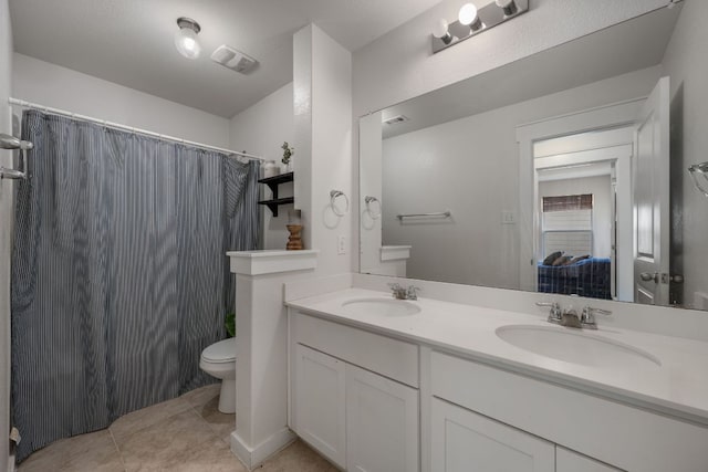 full bathroom featuring visible vents, toilet, double vanity, and a sink