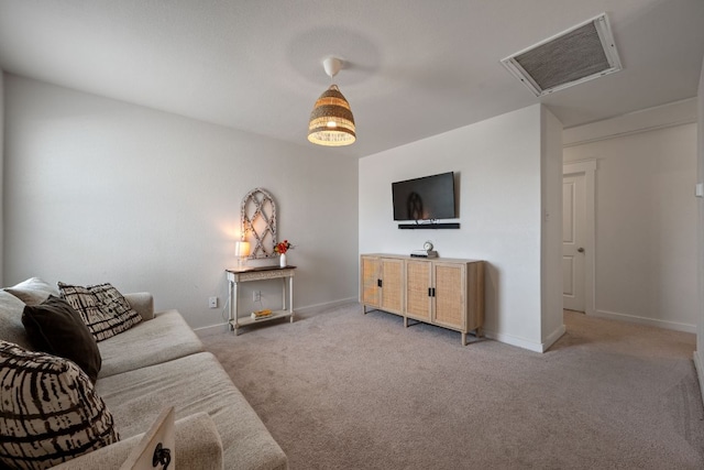living area with baseboards, visible vents, attic access, and light colored carpet