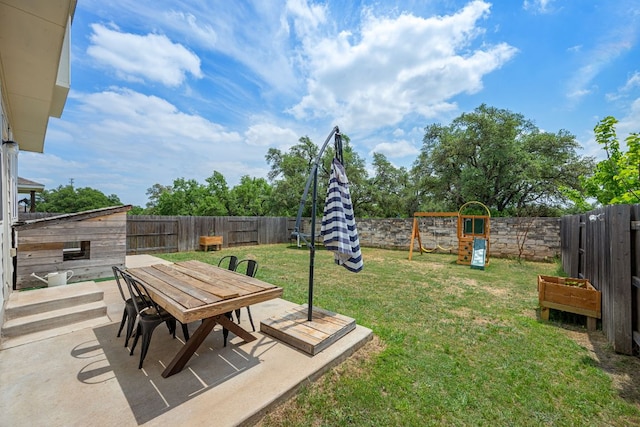 view of yard with a patio, outdoor dining area, a playground, and a fenced backyard