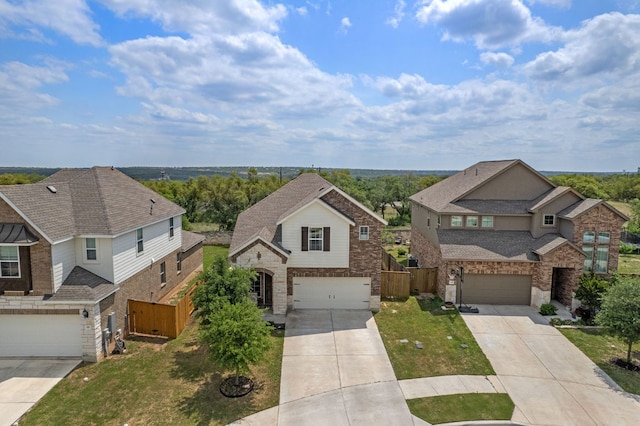 view of front facade with fence, a residential view, concrete driveway, and an attached garage