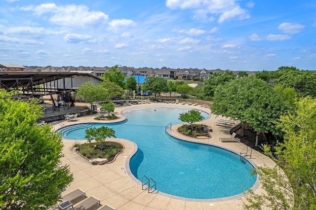pool with a patio area and a residential view