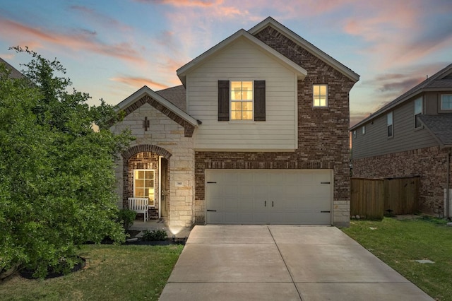traditional-style home with an attached garage, fence, stone siding, concrete driveway, and a lawn
