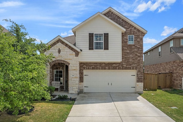 traditional-style house with driveway, stone siding, fence, a front lawn, and a garage