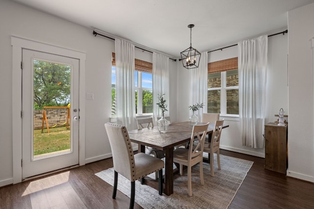 dining room featuring dark wood-style flooring, baseboards, a chandelier, and a healthy amount of sunlight