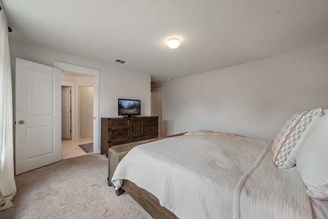 bedroom with visible vents and light carpet