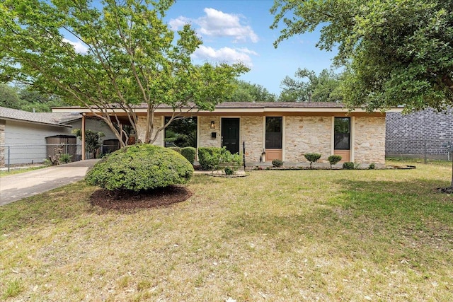 single story home featuring fence, driveway, a front yard, and stone siding