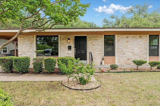 view of front of property featuring a front lawn and stone siding
