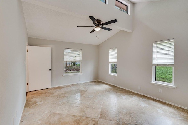 spare room with a healthy amount of sunlight, ceiling fan, high vaulted ceiling, and baseboards