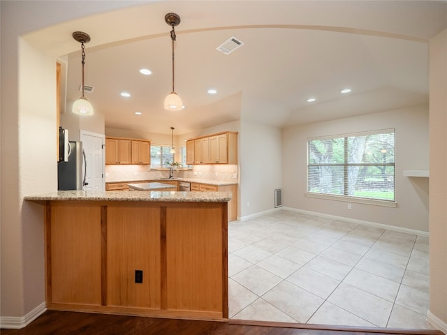 2912 Norton Ave, Lago Vista, TX 78645 - kitchen with a peninsula, fridge, light stone counters, tasteful backsplash, and recessed lighting