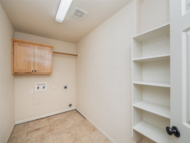 2912 Norton Ave, Lago Vista, TX 78645 - laundry room featuring electric dryer hookup, cabinet space, light tile patterned flooring, washer hookup, and hookup for a gas dryer