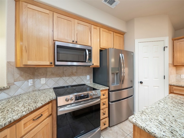 2912 Norton Ave, Lago Vista, TX 78645 - kitchen featuring stainless steel appliances, decorative backsplash, light stone counters, and light brown cabinets