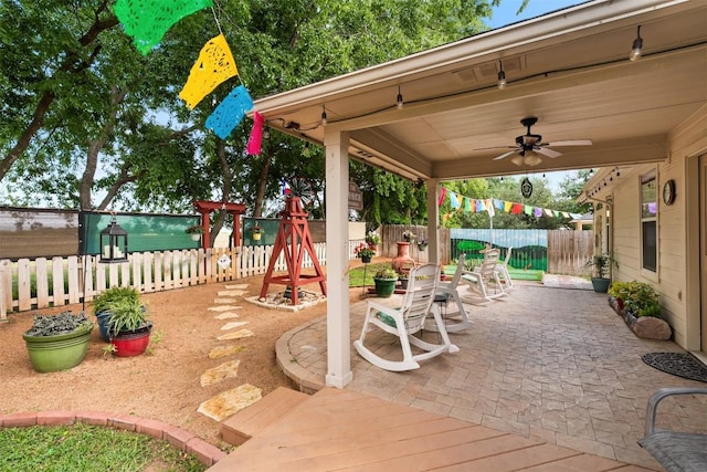 30310 Bumble Bee Dr, Georgetown, TX 78628 - view of patio with a fenced backyard, a ceiling fan, outdoor dining space, and a playground