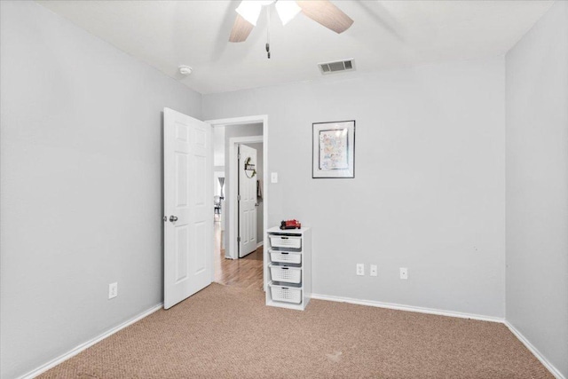 107 Jefferson Cv, Elgin, TX 78621 - unfurnished bedroom with baseboards, visible vents, a ceiling fan, and light carpet