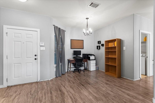 107 Jefferson Cv, Elgin, TX 78621 - home office featuring washer / dryer, visible vents, wood finished floors, and an inviting chandelier