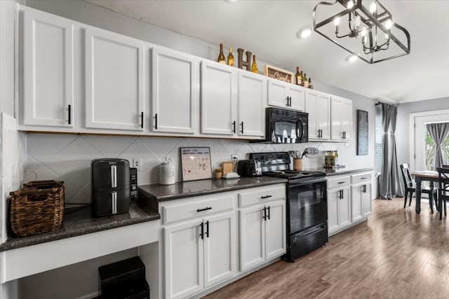 107 Jefferson Cv, Elgin, TX 78621 - kitchen featuring white cabinets, a chandelier, black appliances, wood finished floors, and backsplash