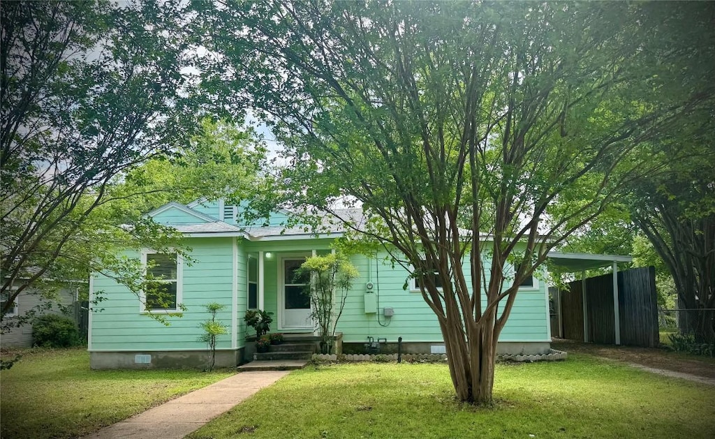 view of front of property with fence, entry steps, and a front yard