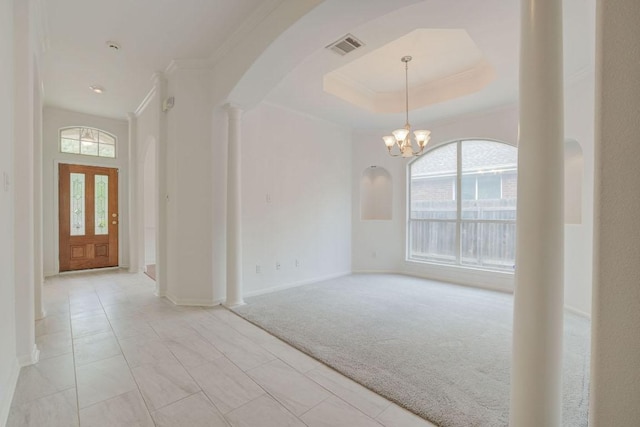 entrance foyer featuring arched walkways, light carpet, crown molding, and plenty of natural light