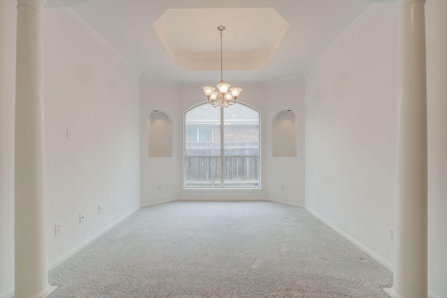 carpeted empty room with baseboards, a raised ceiling, a notable chandelier, and ornamental molding