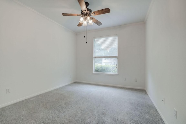 carpeted empty room featuring crown molding, a ceiling fan, and baseboards