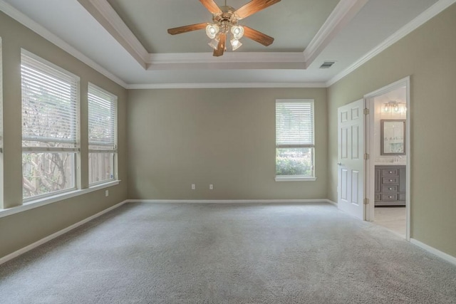 spare room with visible vents, ceiling fan, carpet floors, and a tray ceiling