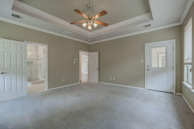 unfurnished bedroom featuring visible vents, carpet floors, crown molding, and a tray ceiling