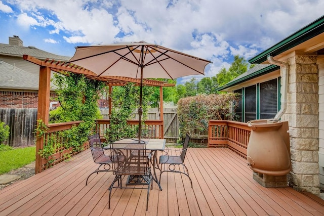 wooden terrace with outdoor dining space and a fenced backyard