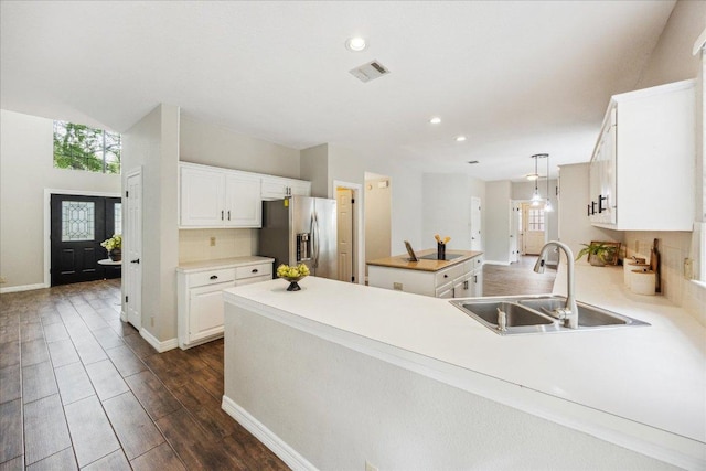 9007 Tweed Berwick Dr, Austin, TX 78750 - kitchen with stainless steel fridge with ice dispenser, a sink, a peninsula, white cabinetry, and recessed lighting
