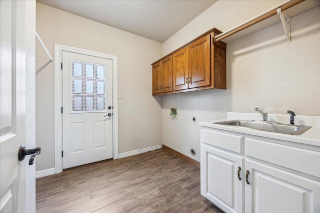 9007 Tweed Berwick Dr, Austin, TX 78750 - laundry room with cabinet space, a sink, hookup for a washing machine, wood finished floors, and hookup for an electric dryer