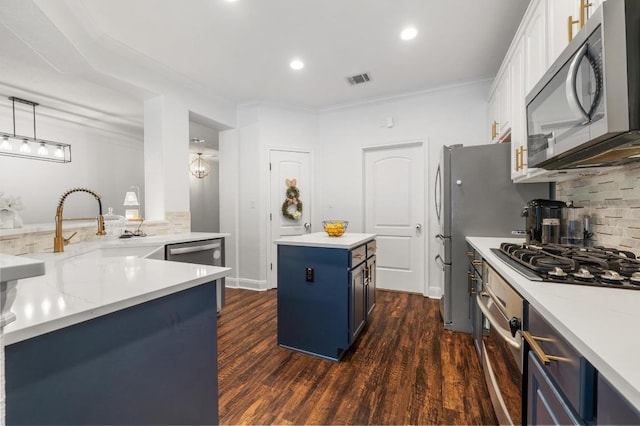 108 Perpetuation Dr Unit 802, Lakeway, TX 78734 - kitchen featuring appliances with stainless steel finishes, blue cabinets, a kitchen island, backsplash, and dark wood finished floors