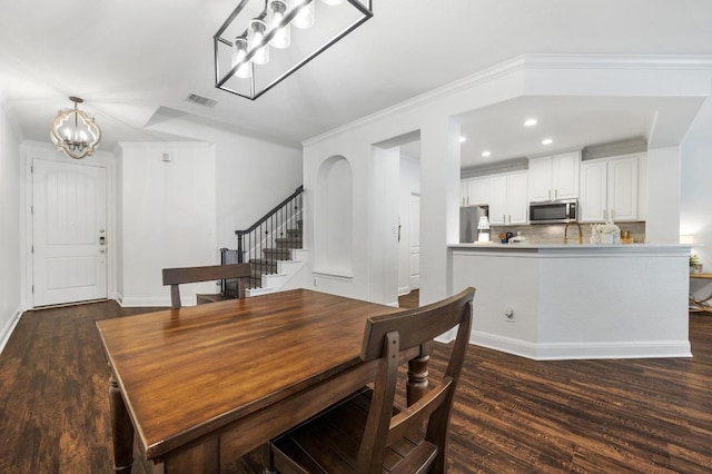 108 Perpetuation Dr, Austin, TX 78734 - dining area featuring a chandelier, dark wood-style flooring, stairway, crown molding, and recessed lighting
