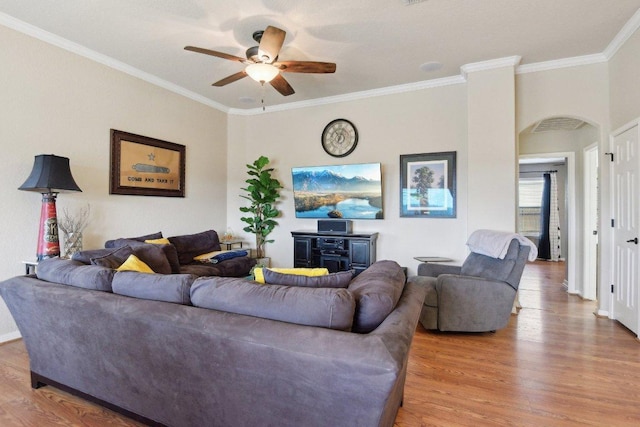 living room featuring wood finished floors, ceiling fan, crown molding, and baseboards