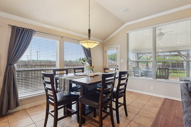 dining space with light tile patterned flooring, crown molding, vaulted ceiling, and baseboards