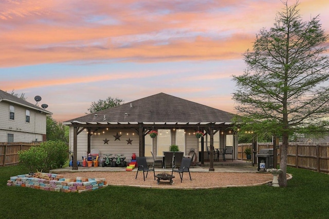 back of house with a pergola, a lawn, a fenced backyard, and an outdoor fire pit