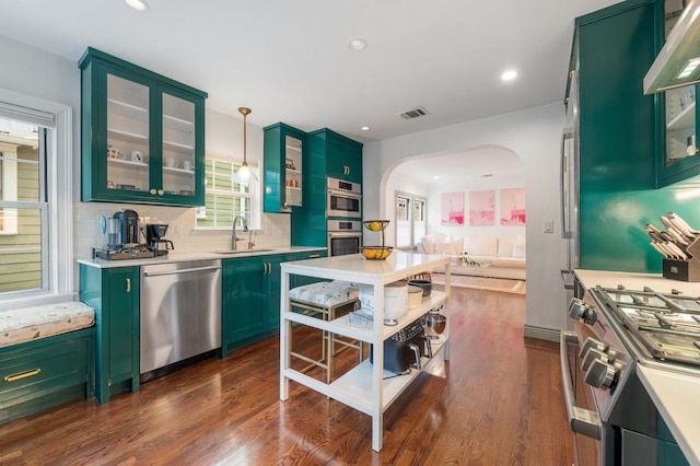 1107 Maufrais St, Austin, TX 78703 - kitchen featuring green cabinets, stainless steel appliances, arched walkways, light countertops, and recessed lighting