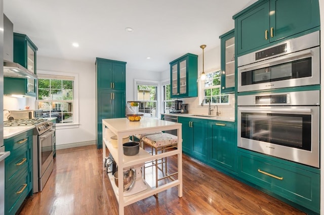 1107 Maufrais St, Austin, TX 78703 - kitchen with appliances with stainless steel finishes, light countertops, healthy amount of natural light, wall chimney range hood, and recessed lighting