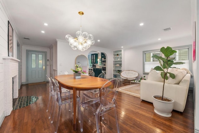 1107 Maufrais St, Austin, TX 78703 - dining space with arched walkways, ornamental molding, wood finished floors, recessed lighting, and a brick fireplace