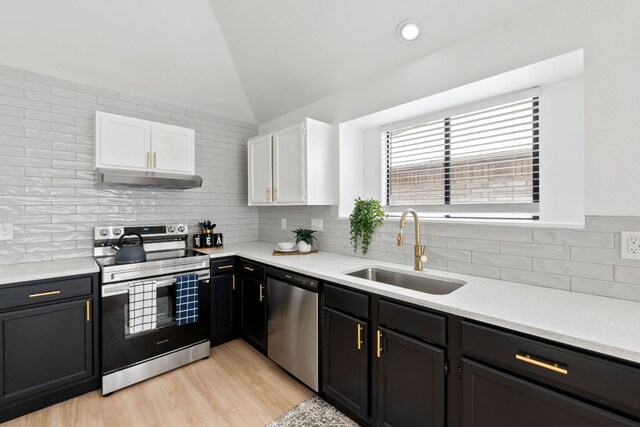 609 Clearwater Trl, Round Rock, TX 78664 - kitchen with appliances with stainless steel finishes, a sink, white cabinets, decorative backsplash, and lofted ceiling