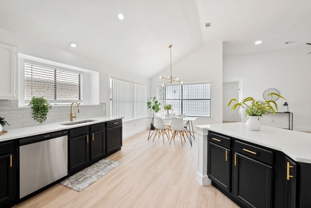 609 Clearwater Trl, Round Rock, TX 78664 - kitchen featuring stainless steel dishwasher, a sink, dark cabinets, decorative backsplash, and vaulted ceiling