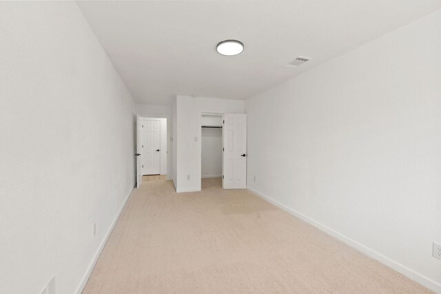 609 Clearwater Trl, Round Rock, TX 78664 - unfurnished bedroom featuring light colored carpet, baseboards, a closet, and a walk in closet